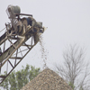 Rock bailer adding rocks to the top of pile at Gale Briggs Inc property