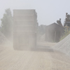 Truck driving away with dust behind it