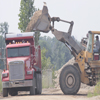 Bulldozer loading dirt and gravel onto back of dump truck on the Gale Briggs Inc property in Charlotte, Michigan